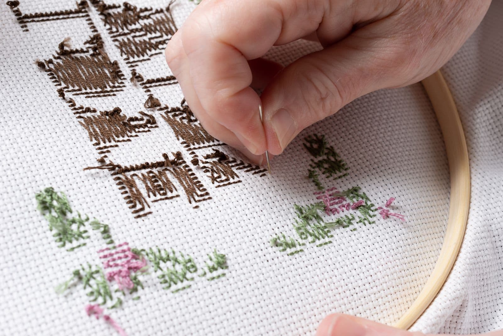 Close-up detail of hand cross-stitch floral thread embroidery